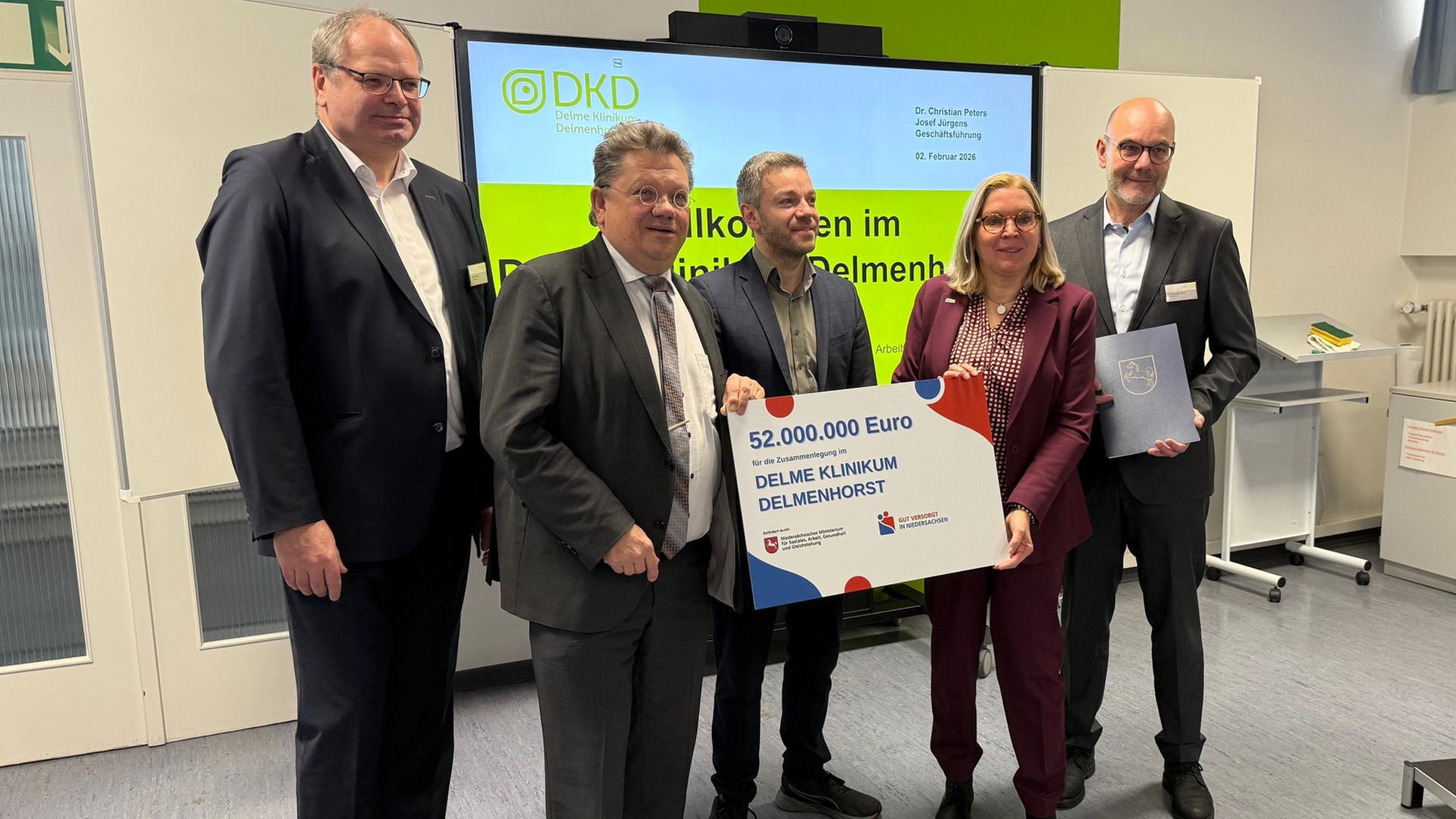 Mehrer Menschen stehen hionter einem groß Plakat auf dem die Zahl 52.000.000 Euro steht. | NDR, Maja Chiara Hülcher