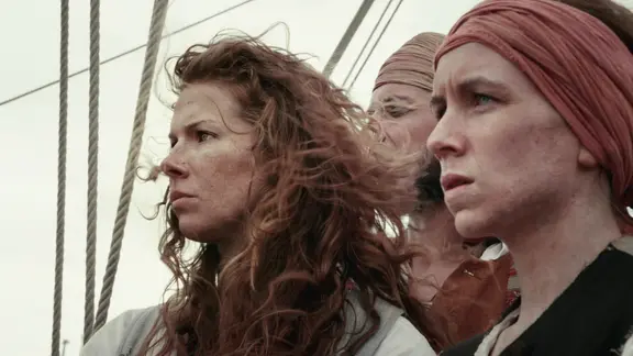 Zwei Piratinnen stehen an Deck und schauen aufs Meer.