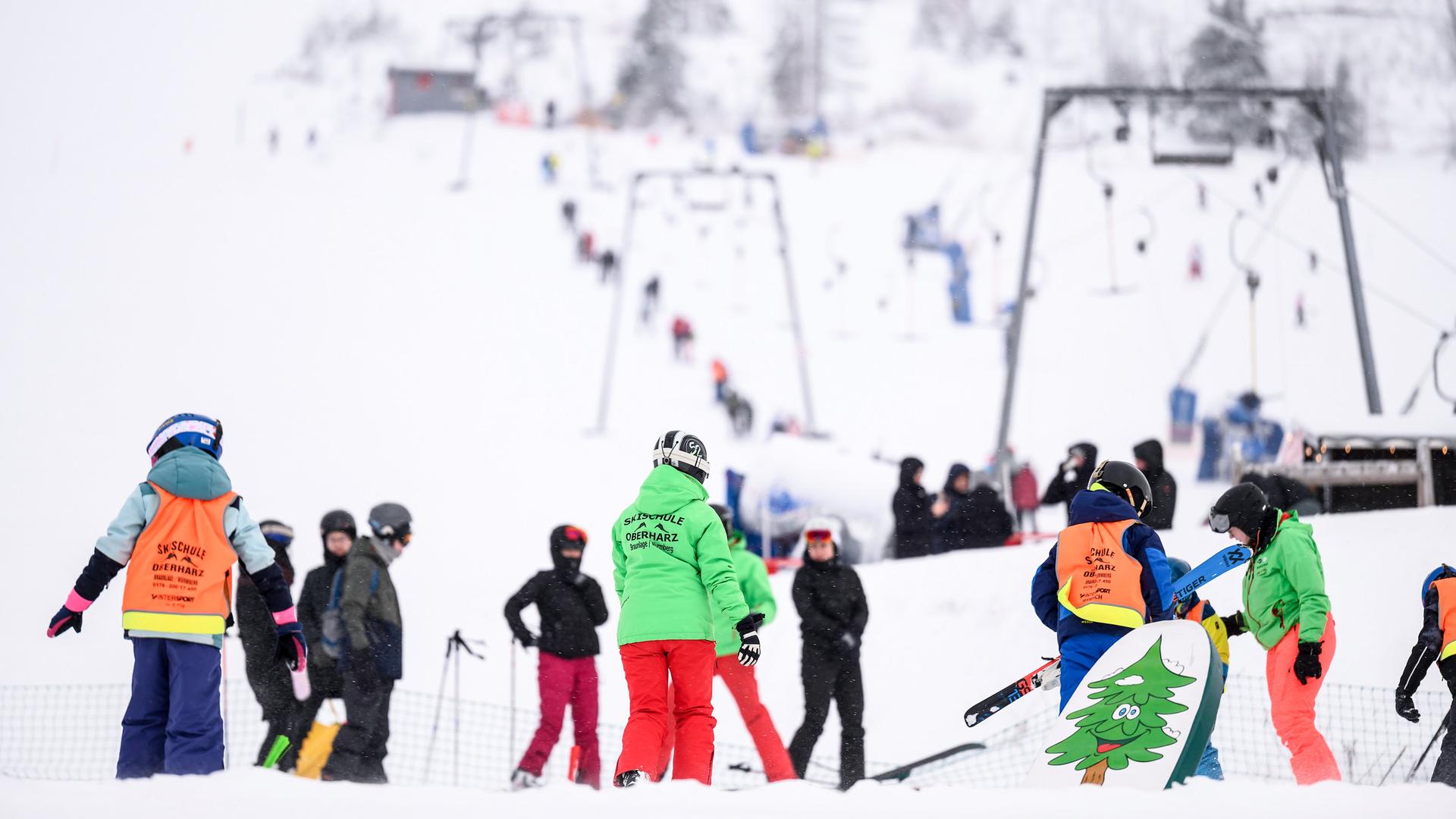 Skilehrer stehen mit Wintersportlern auf einer Skipiste am Wurmberg. | dpa, Swen Pförtner