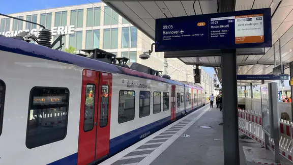Eine S-Bahn hält an einem Bahnsteig, an welchem noch letzte Absperrungen stehen.