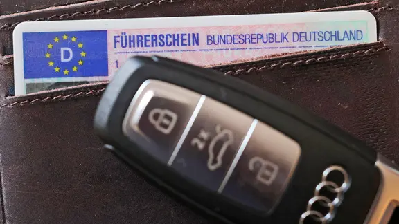 Nahaufnahme eines Führerscheins in einem Portemonnaie, davor ein Autoschlüssel. 