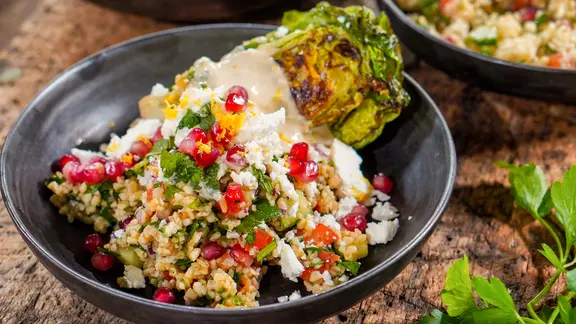 Taboulé-Salat mit Feta und einem halben Römersalatherz in einer Schüssel serviert