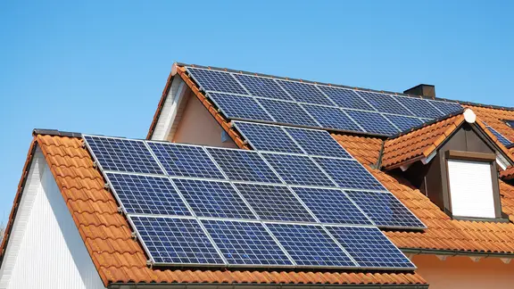 Ein Hausdach mit Sonnenkollektoren.