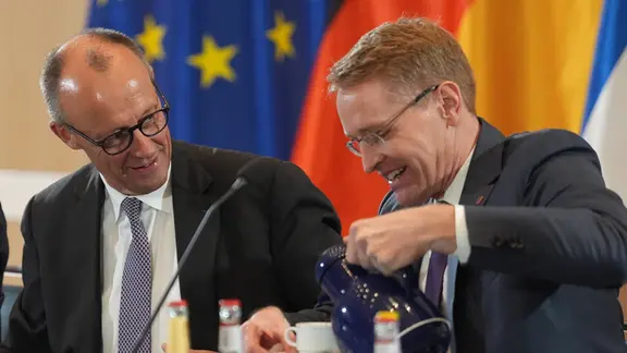 Bundeskanzler Friedrich Merz (l., CDU) sitzt neben Daniel Günther (CDU), Ministerpräsident von Schleswig-Holstein, im Husumer Rathaus während der Sitzung des Außenkabinetts der Landesregierung.