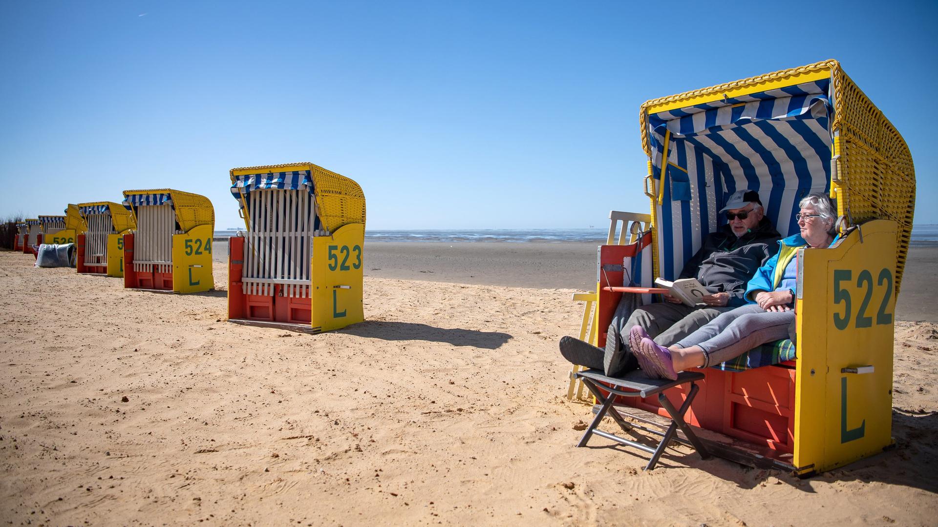 Ein Ehepaar sitzt in einem Strandkorb am Meer. | picture alliance/dpa | Sina Schuldt