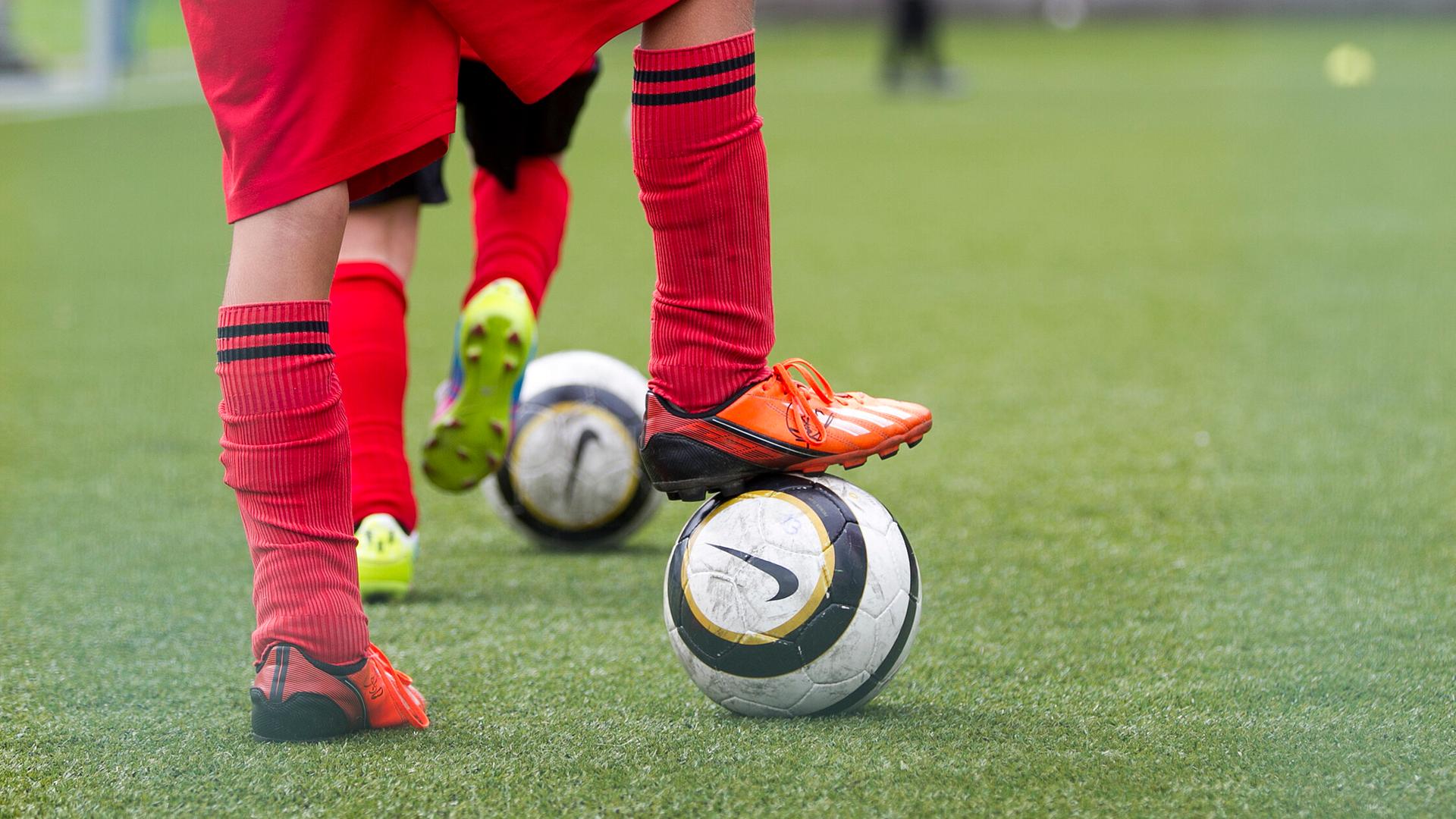 Ein jugendlicher Spieler stellt seinen Fuß auf einem Fußball ab. | picture alliance / Eibner-Pressefoto | Eibner-Pressefoto