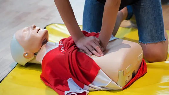 Ein Schüler trainiert eine Herzdruckmassage an einer Übungspuppe.