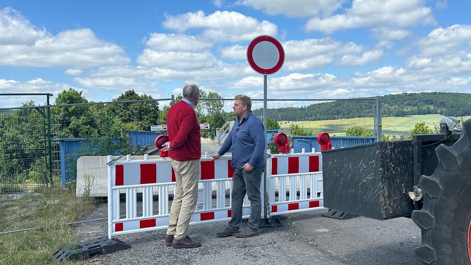 Christian von Plate-Stralenheim von der Feldmarksgenossenschaft und Ortsbürgermeister Jan-David Schmidt beklagen die derzeitige Situation. | Doretta Farnbacher Christian von Plate-Stralenheim von der Feldmarksgenossenschaft und Ortsbürgermeister Jan-David Schmidt (parteilos) stehen an der gesperrten Brücke in Imbshausen.