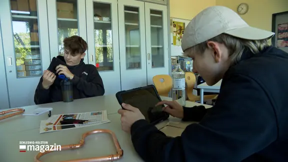 Junge Menschen informieren sich im Unterricht über Handwerksbetriebe