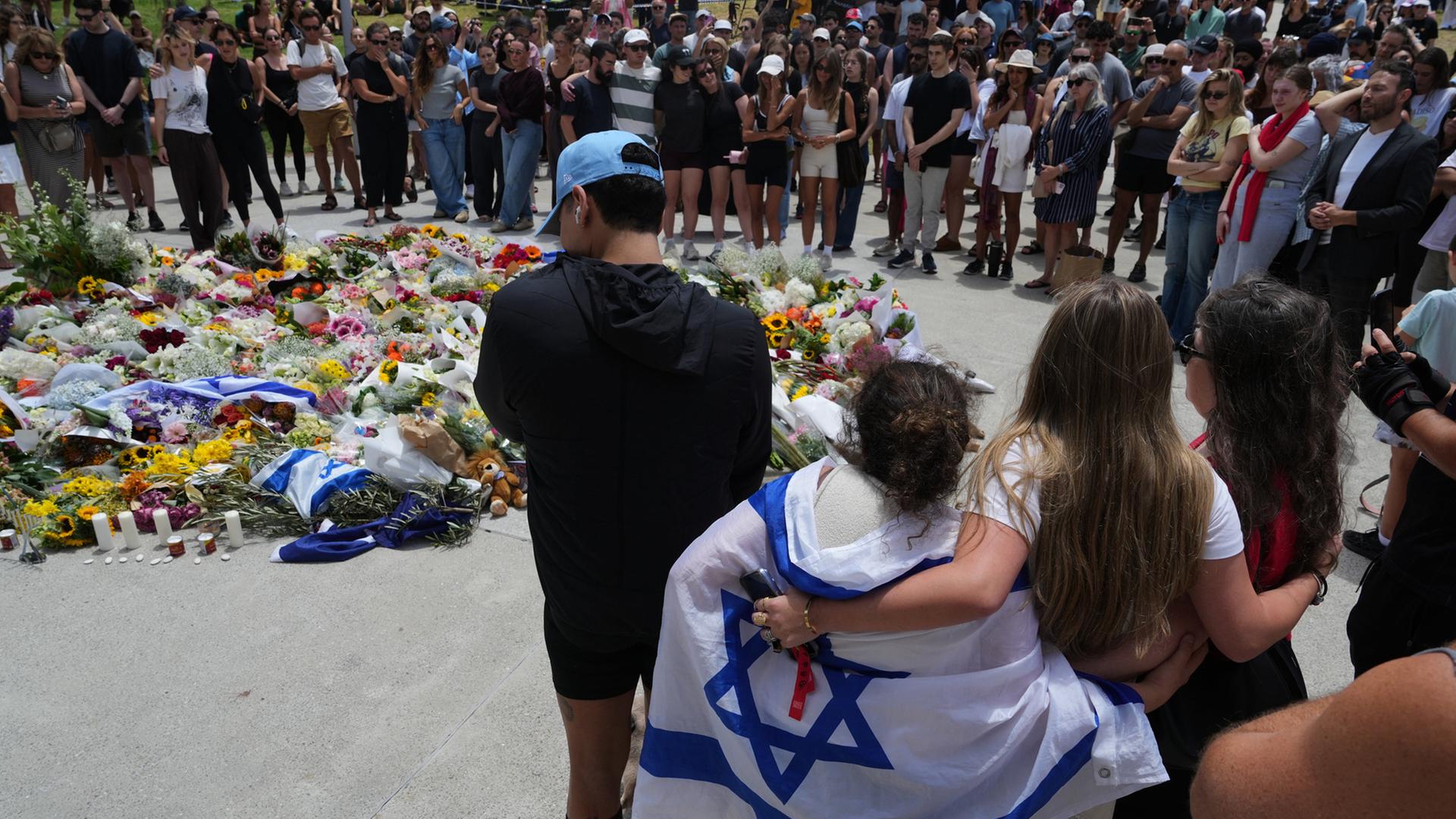 Menschen versammeln sich einen Tag nach einer Schießerei, vor dem Bondi Pavilion am Bondi Beach in Sydney | Mark Baker/AAP/dpa