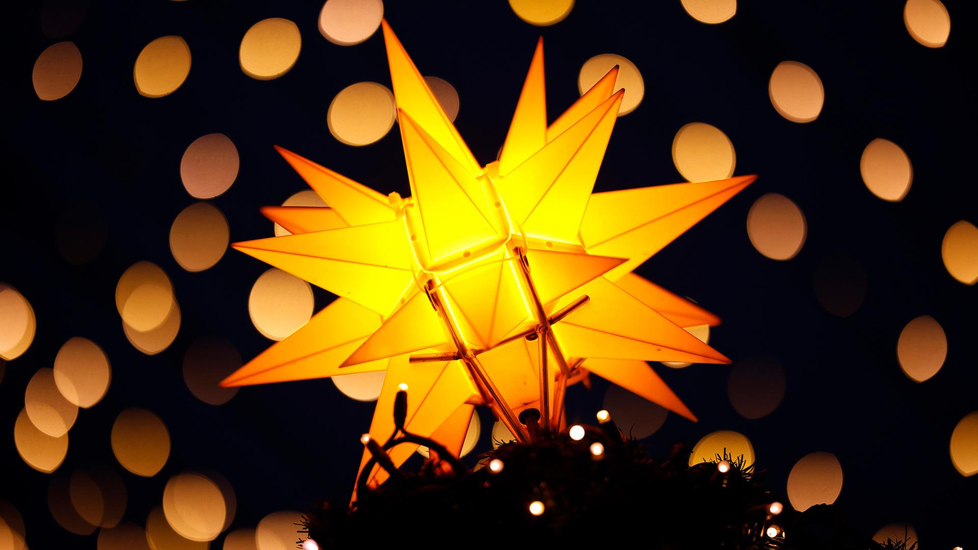 Leuchtender Stern und Lichterketten. | picture alliance/Panama Pictures, Christoph Hardt