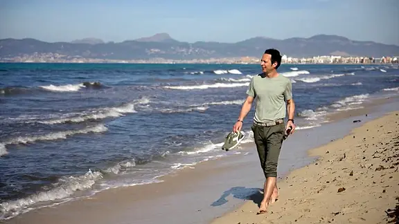 Jo Hiller geht am Strand von Mallorca spazieren.