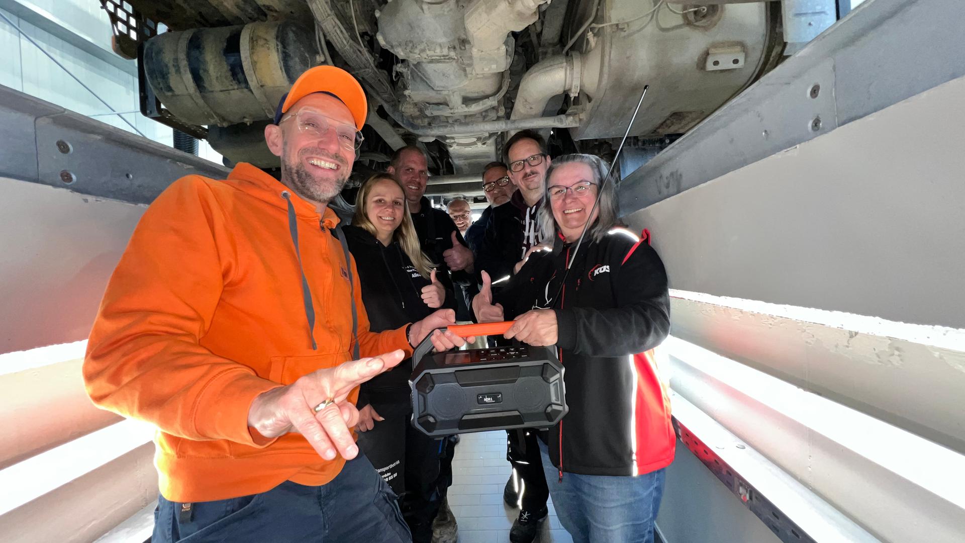 Schorse übergibt ein Dabbi DAB+ Radio an das Team der KÜS Kfz-Prüfstelle in Zetel. | NDR, Viktoria Krumme