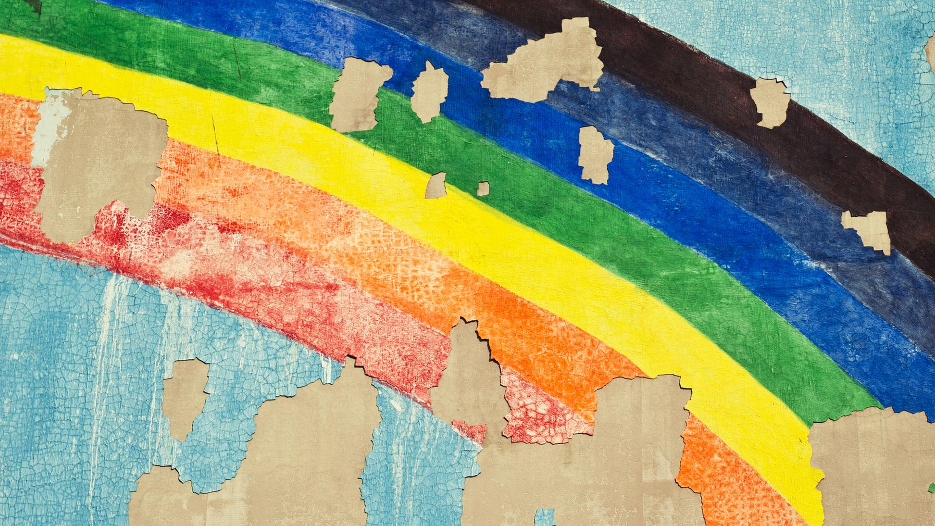 Ein Regenbogen auf eine Wand gemalt, bei der die Farbe abblättert. | photocase/suze
