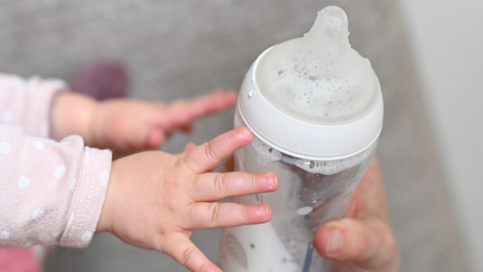 Ein Baby greift nach einer Flasche (Themenbild). | APA/picturedesk.com, Barbara Gindl