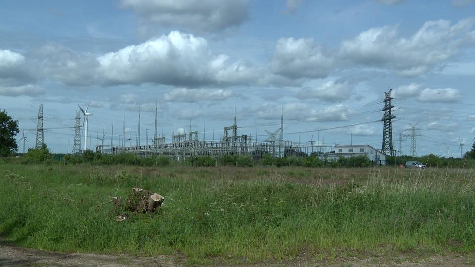 Das Umspannwerk Schuby ist ein attraktiver Punkt bei den Planungen für Rechenzentren. | NDR Das Umspannwerk Schuby mit Transformatoren und Stromleitungen umgeben von Grünland.