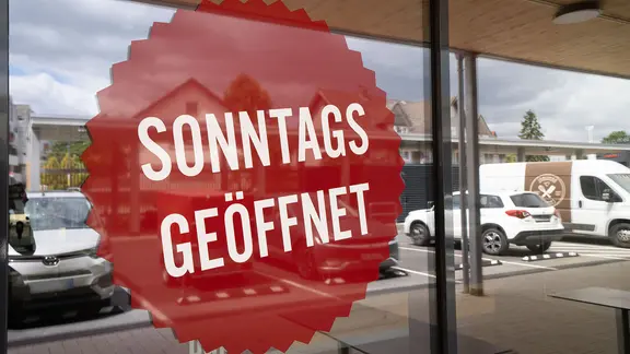 "Sonntags geöffnet" steht an der Schaufensterscheibe eines Geschäftes. | picture-aliance, Frank Rumpenhorst "Sonntags geöffnet" steht an der Schaufensterscheibe eines Geschäftes.