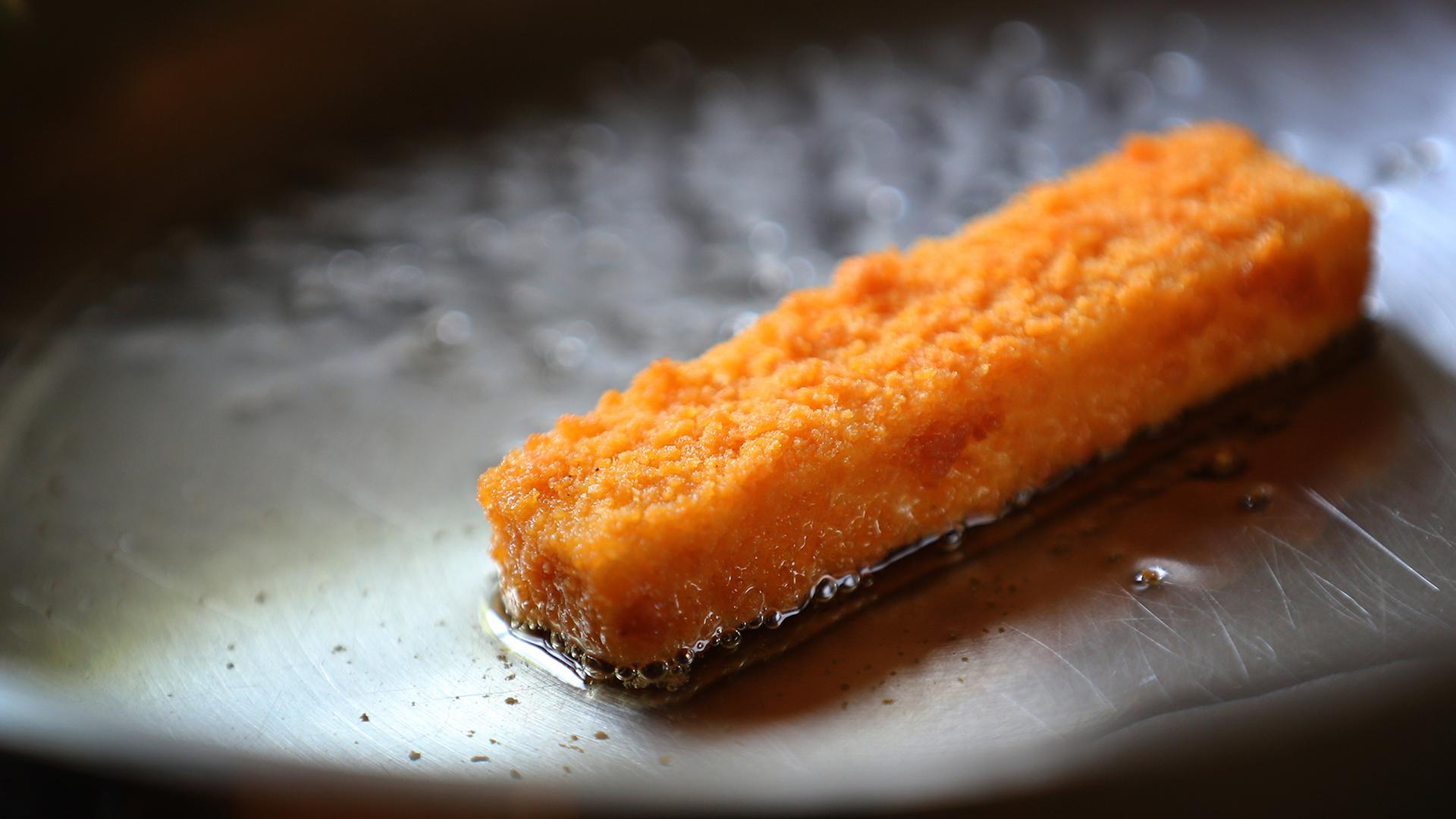 Ein veganes Fischstäbchen in einer Pfanne. | picture alliance / dpa, Karl-Josef Hildenbrand
