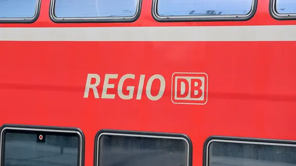 Das Regio Deutsche Bahn Logo mit Schriftzug auf der Seite eines Wagons.