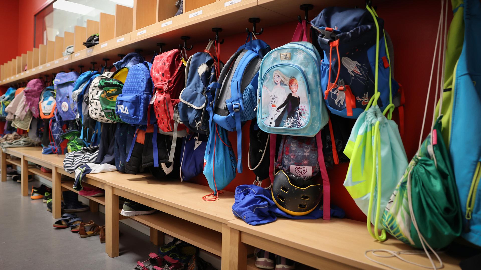 Sporttaschen und Schulranzen hängen an der Garderobe in einer Grundschule in Hamburg. | picture alliance / dpa, Christian Charisius