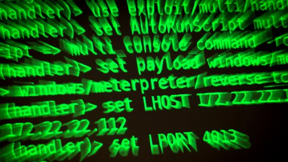 Buchstaben und Zahlen leuchten auf einem Bildschirm, auf dem ein Hacker-Programm geöffnet ist.