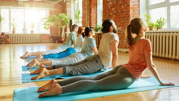 Eine Gruppe praktiziert die Yoga-Übbung Kobra.