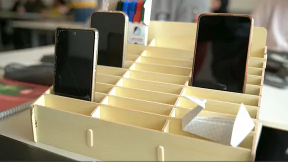 Mehrere schwarze Smartphones stehen in einer Schale.