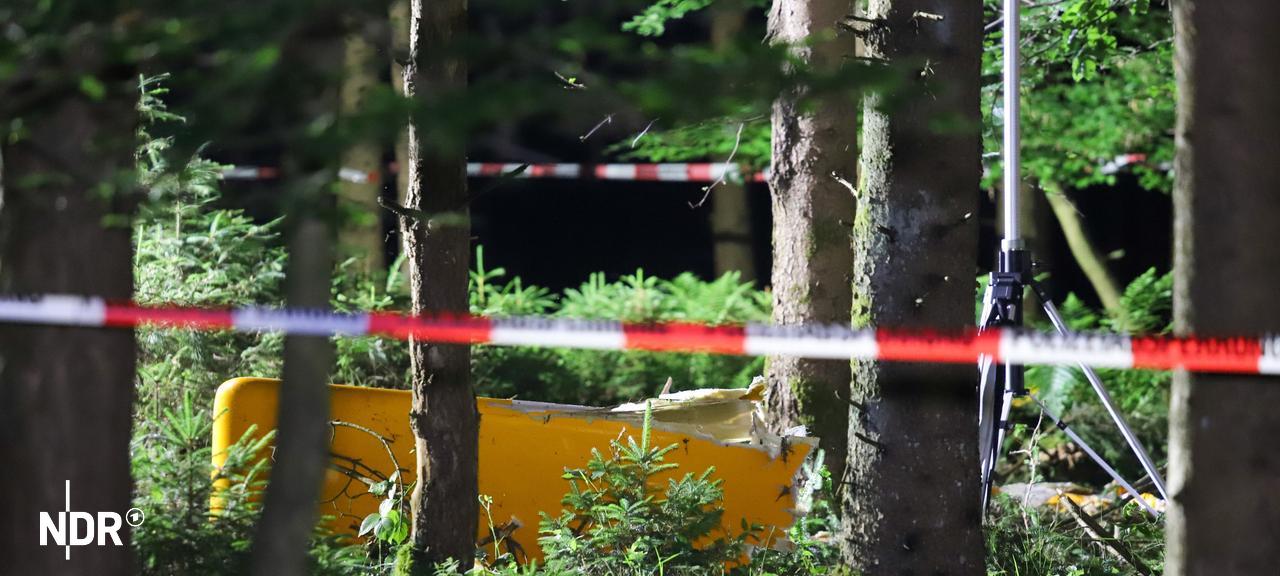 Die Umstände des Absturzes sowie die Unfallursache werden von der Bundesstelle für Flugunfalluntersuchung (BFU) ermittelt. | ndr, Florian Sprenger In einem Waldstück liegt ein Teil eines Flugzeugs, abgesperrt mit Flatterband.