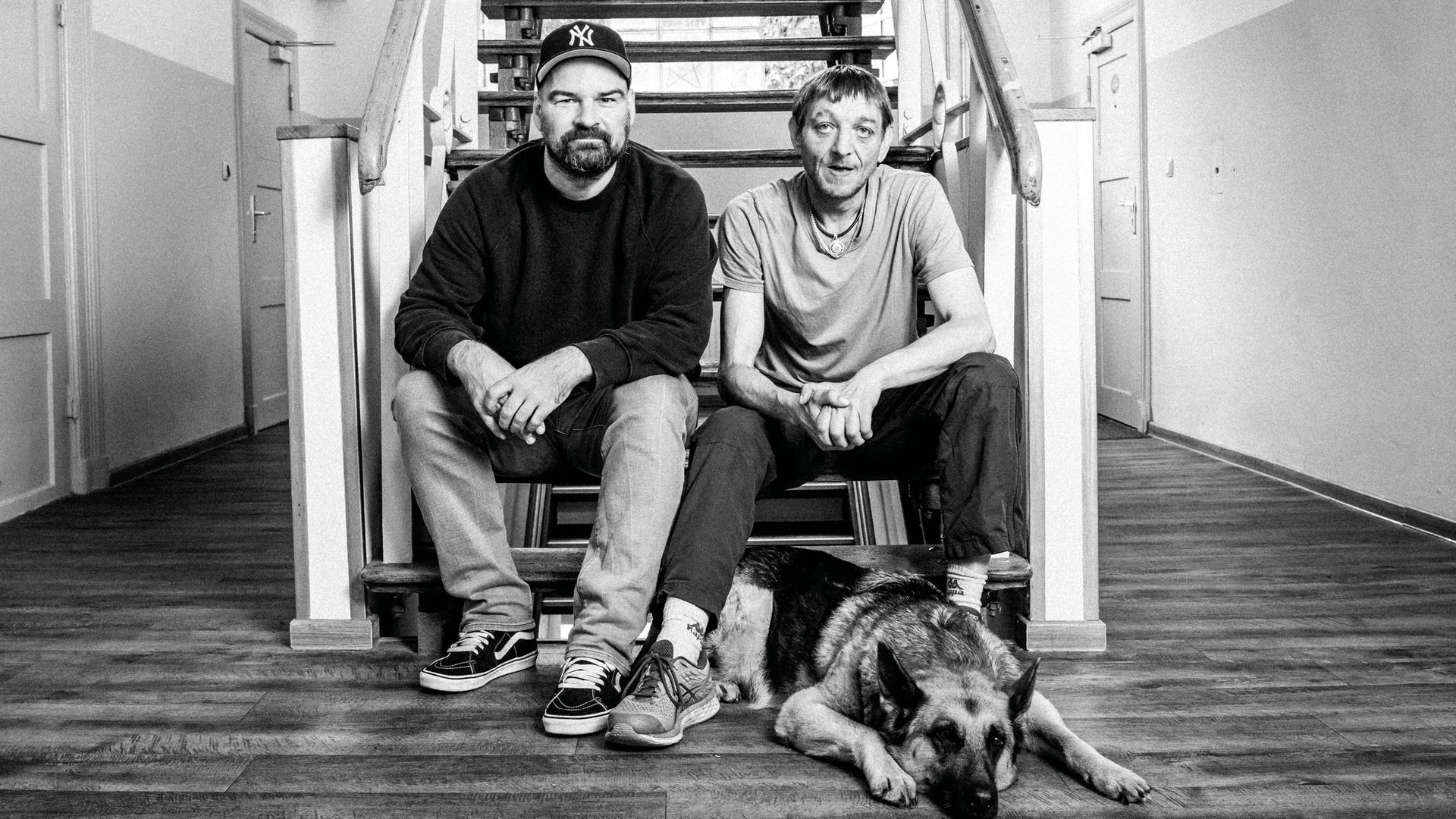 Fotograf Mathias Mensch (l.) sitzt mit Markus B. auf einer Treppe. | studio Mensch, Mathias Mensch