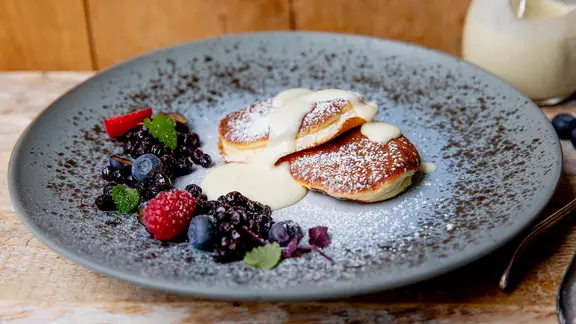 Pancakes mit Ahornsirup auf einem Teller serviert