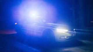 Ein Polizeiauto ist in der Dunkelheit mit Blaulicht im Einsatz.