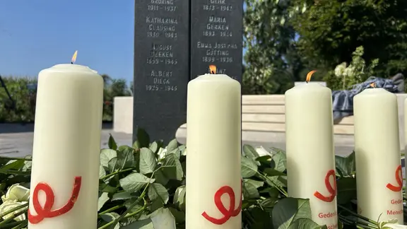 Kerzen brennen vor einer Stehle an der "Gedenkstätte für die Menschenwürde" in Vechta.