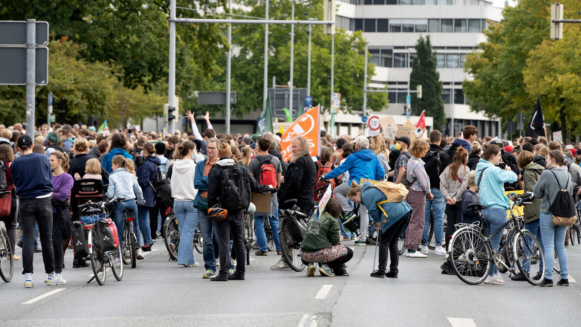 Teilnehmer einer Demo stehen und hocken auf einer Straße. | picture alliance/Geisler-Fotopress, Patrick Graf/Geisler-Fotopress