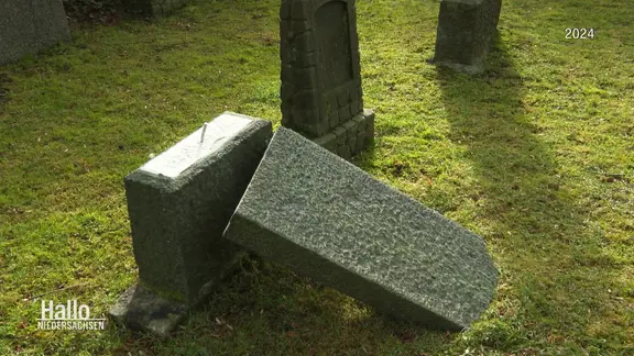 Une pierre tombale endommagée et renversée dans un cimetière juif. (2024) | Capture d'écran Une pierre tombale endommagée et renversée dans un cimetière juif. (2024)