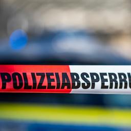 Ein Absperrband mit der Aufschrift «Polizeiabsperrung» ist vor einem Polizeiwagen aufgespannt.