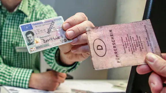 Symbolbild zum Führerschein-Tausch, alt gegen neu: Ein alter Papierführerschein (r.) wird neben einen neuen Muster EU- Führerschein im Scheckkartenformat gehalten.