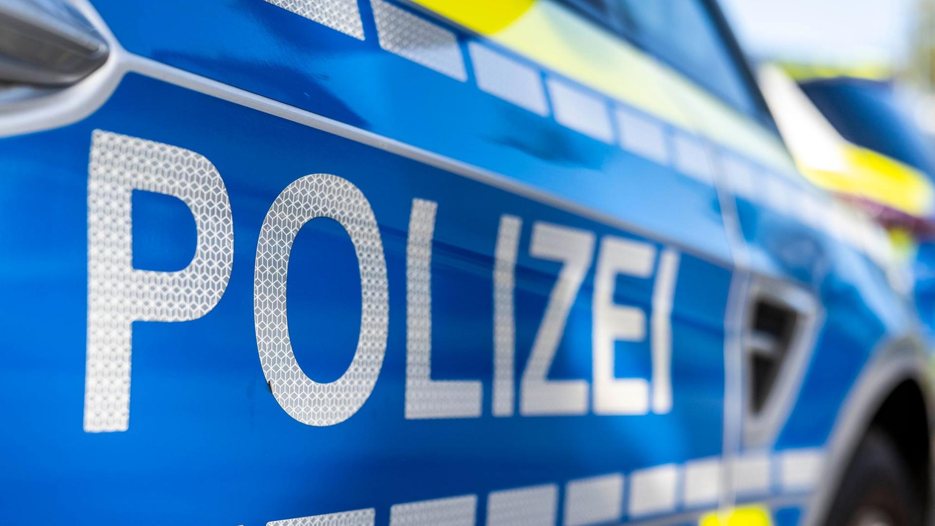 An der Tür von einem Streifenwagen steht der Schriftzug 