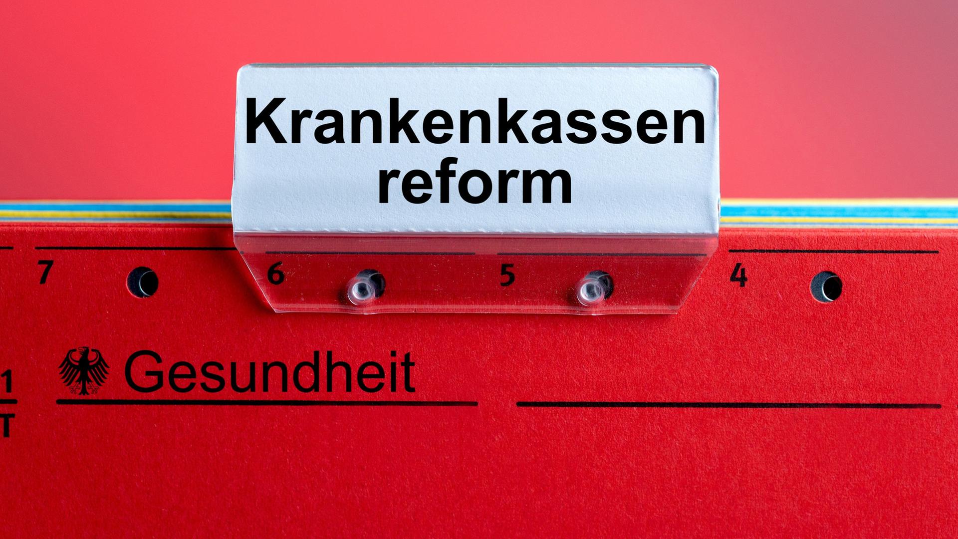 Auf einer roten Hängeregistermappe klemmt ein Sichtreiter mit der Aufschrift 
