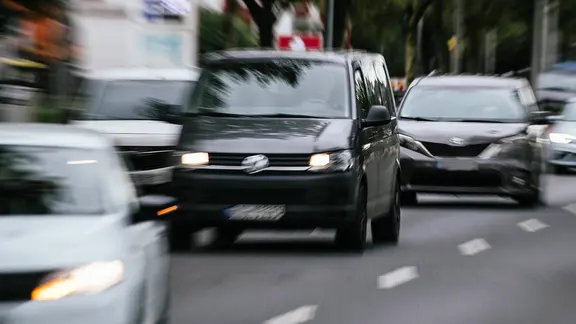 Mit Bewegungsunschärfe fotografierte Autos, die auf einer mehrspurigen Straße unterwegs sind.