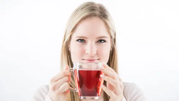 Eine blonde Frau trinkt eine Tasse Tee.