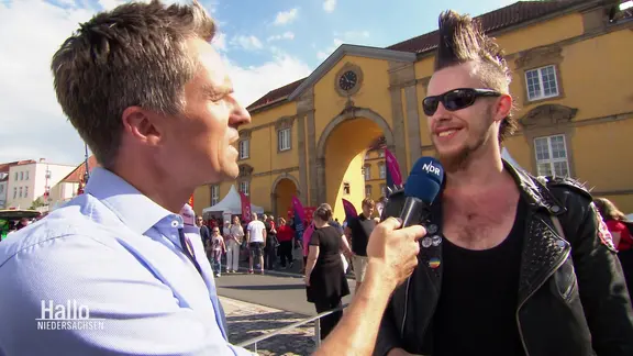 Straßeninterview mit einem Mann mit Sonnenbrille und Irokesenschnitt