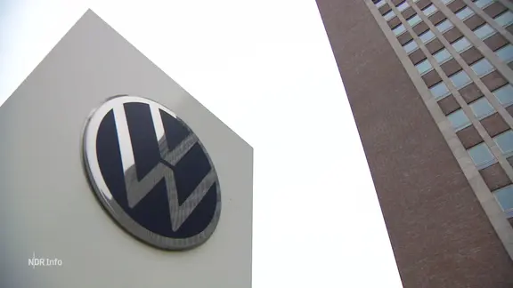 Das Logo von Volkswagen vor einem Gebäude.
