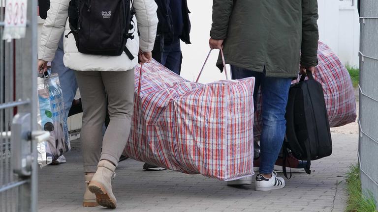 Flüchtlinge aus Syrien kommen mit ihrem Gepäck in einer Erstaufnahmeeinrichtung an.