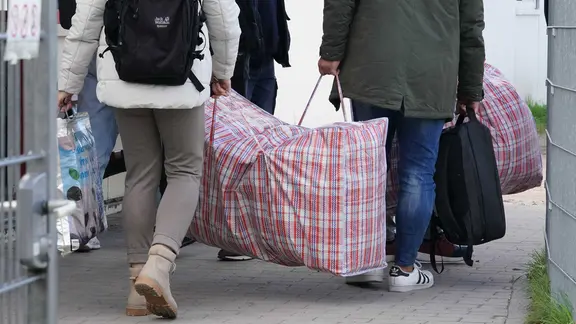 Flüchtlinge aus Syrien kommen mit ihrem Gepäck in einer Erstaufnahmeeinrichtung an. | Marcus Brandt/dpa Flüchtlinge aus Syrien kommen mit ihrem Gepäck in einer Erstaufnahmeeinrichtung an.