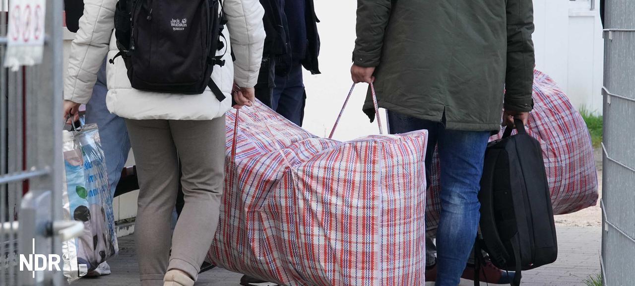 Flüchtlinge aus Syrien kommen mit ihrem Gepäck in einer Erstaufnahmeeinrichtung an. | Marcus Brandt/dpa Flüchtlinge aus Syrien kommen mit ihrem Gepäck in einer Erstaufnahmeeinrichtung an.
