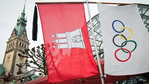Die Olympia-Flagge und die Fahne Hamburgs vor dem Rathaus (Archivfoto) | picture alliance/dpa, Christian Charisius Die Olympia-Flagge und die Fahne Hamburgs vor dem Rathaus (Archivfoto)