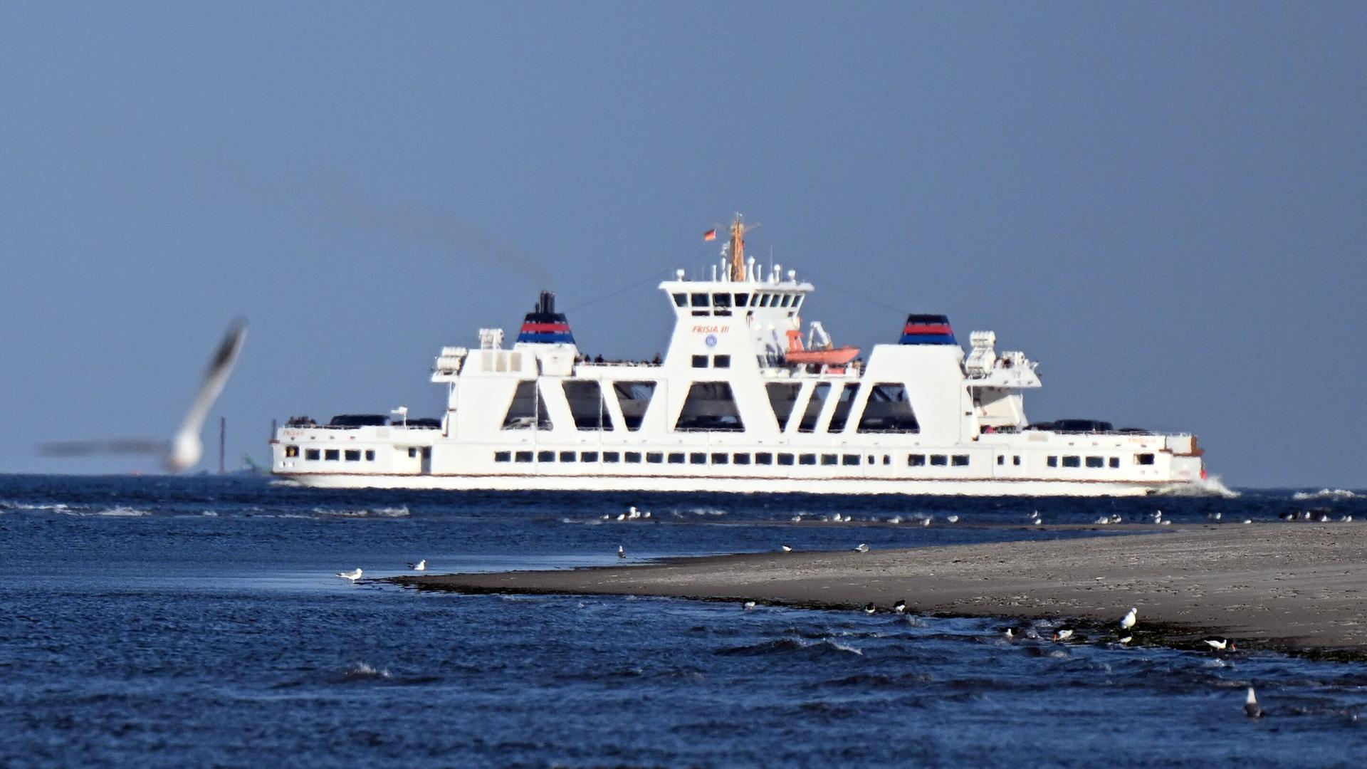 Eine Fähre fährt an der Nordseeinsel Juist vorbei. | picture alliance/dpa | Federico Gambarini