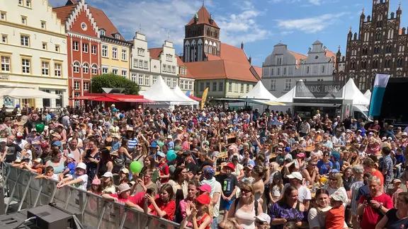 Vor der Bühne am Marktplatz in Greifswald beobachten viele das Programm