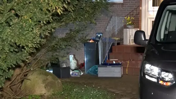 Eine Restmülltonne steht vor einem Wohnhaus.