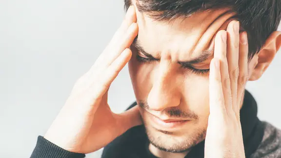 Mann mit schmerzverzerrtem Gesicht hält sich den Kopf (Bild: colourbox.de)